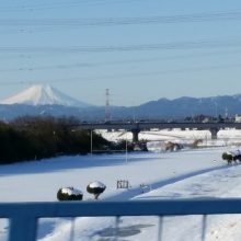 雪の河川敷の先に真っ白い富士山